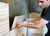 В процессе монтажа плитку аккуратно прикладывают к стене и плотно прижимают к основанию